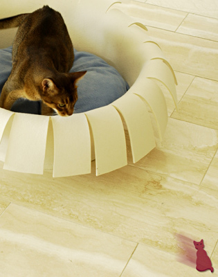 a cat-shaped toy out of wool felt dashes over the smooth floor